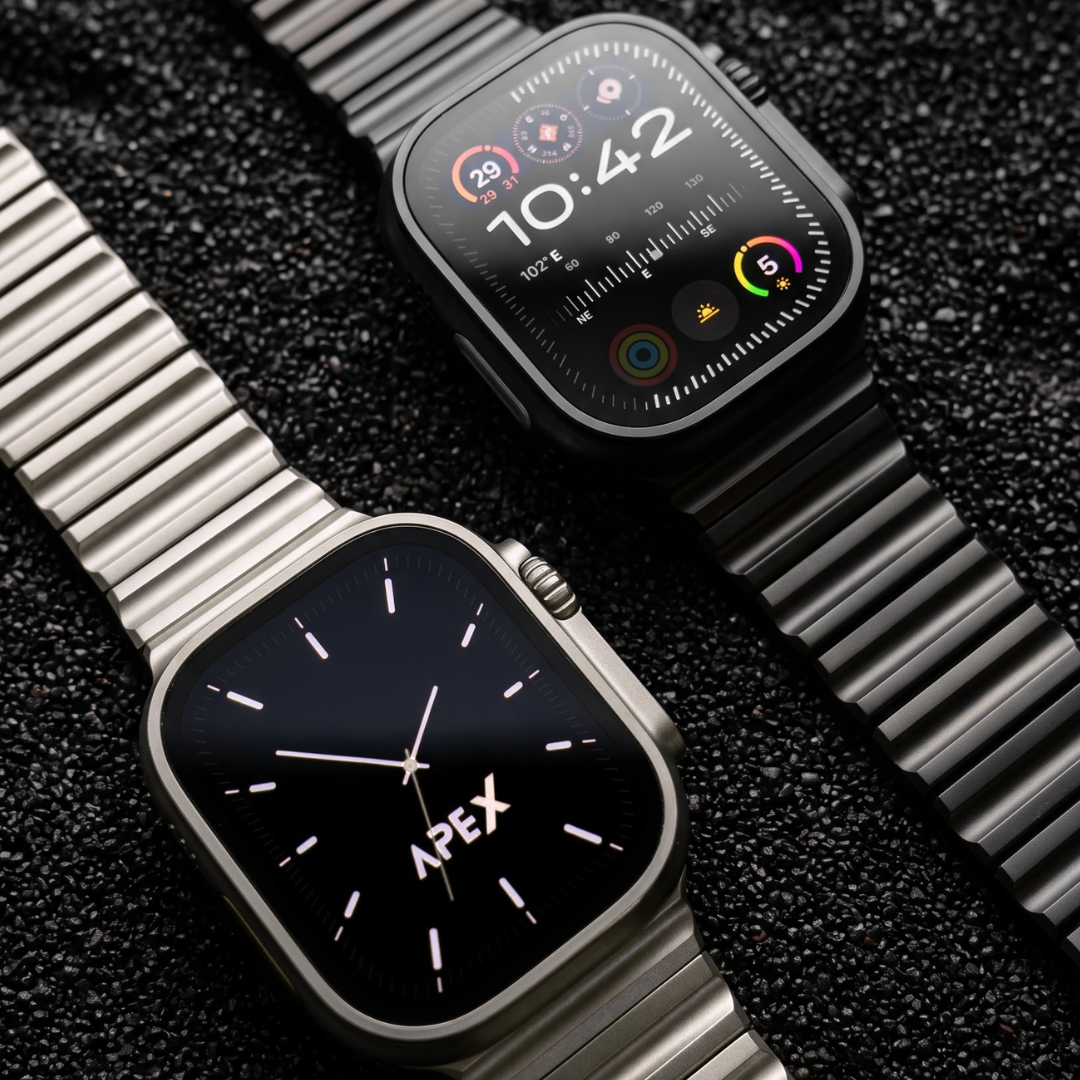 Two Apex smartwatches with metallic links are displayed on a dark textured background. One watch features a black dial with silver-tone hands and markers, while the other features a black digital watch face with colorful app icons.